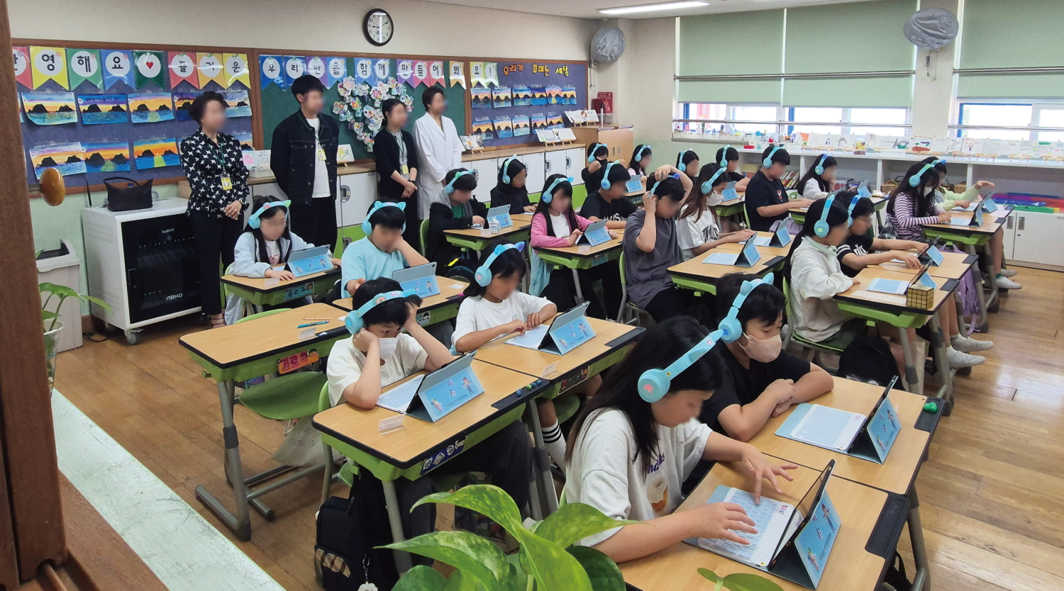 초등학교 교실에서 태블릿으로 참여하는 아이들